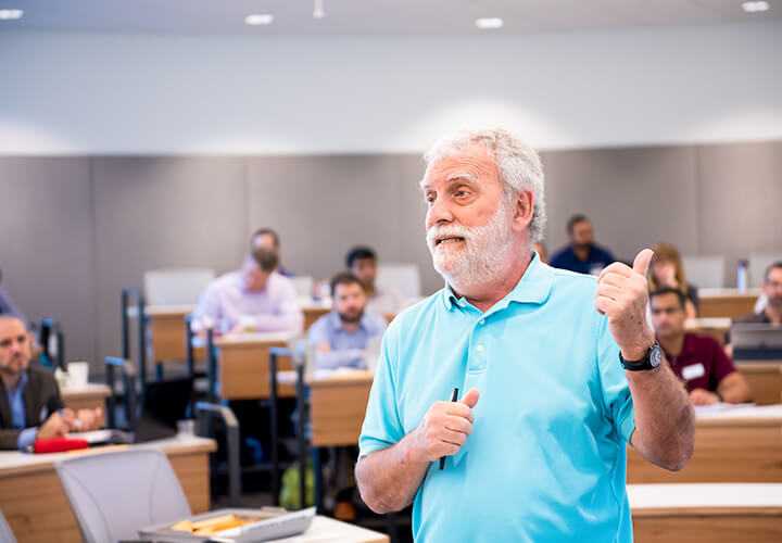 Instructor gestures while standing in front of class teaching
