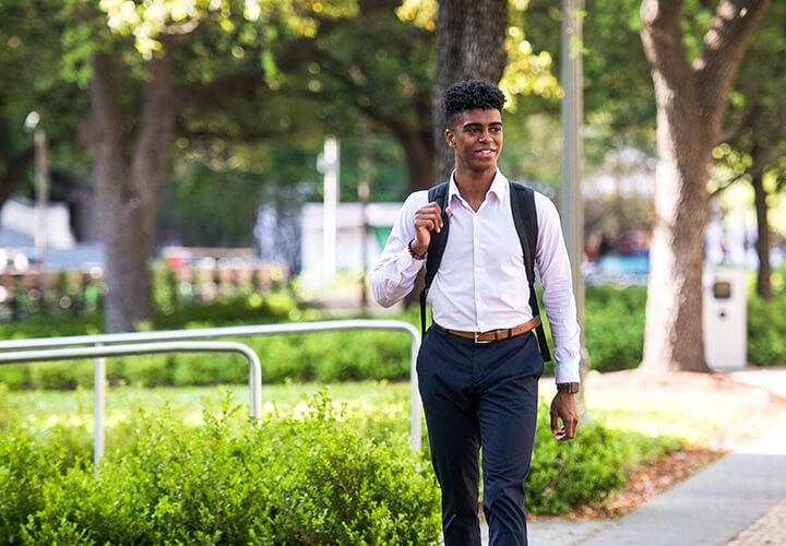 Business casual student walks on campus