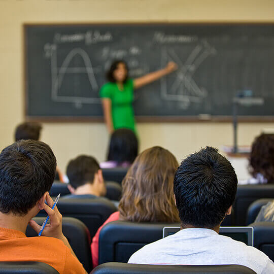Classroom with professor teaching at a chalkboard.