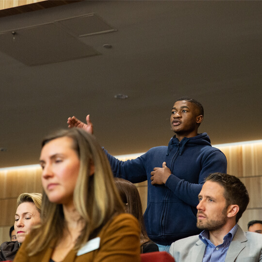 Student stands and asks a question in lecture hall
