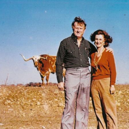 Red McCombs and his wife Charlene pose in front of a longhorn on a ranch