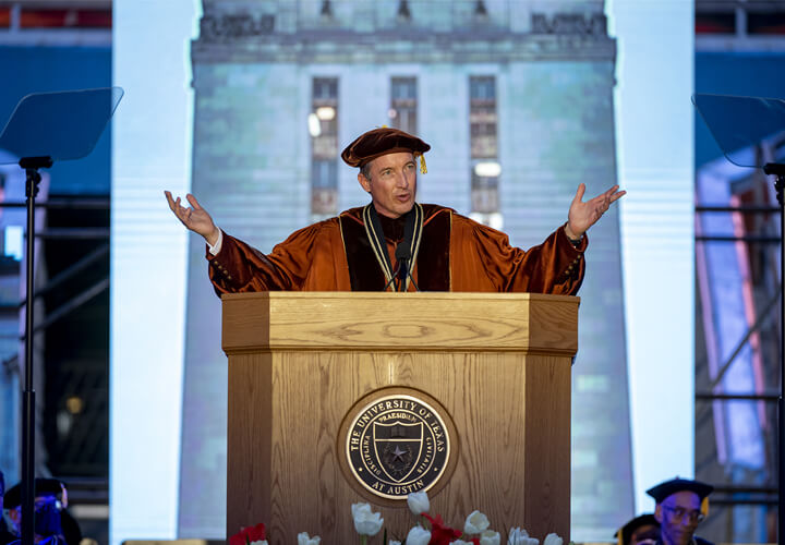 Jay Hartzell gestures while speaking at commencement podium