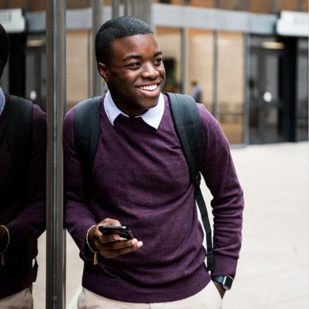 A smiling student holding a phone