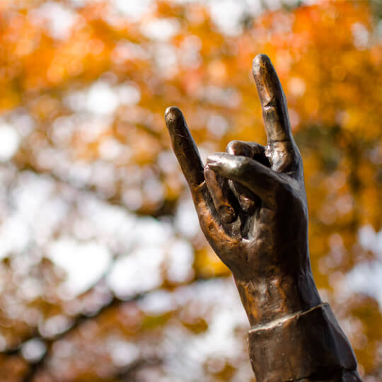Closeup of statue hand giving hook em horns