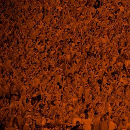 Orange tone picture of crowd of fans at a football game