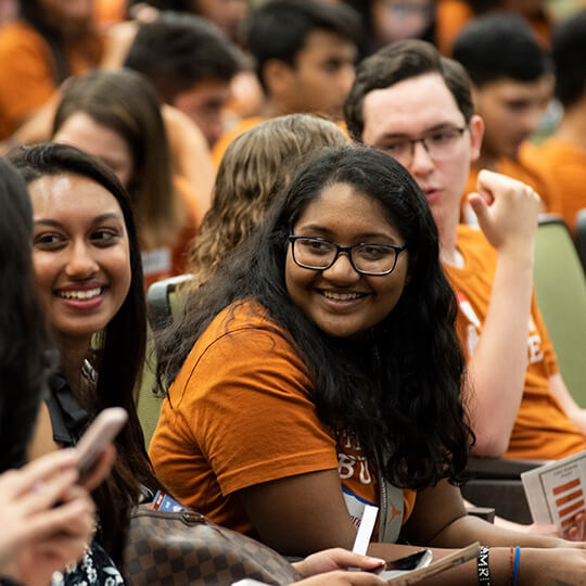 Students laugh in lecture hall at Gone to Texas event