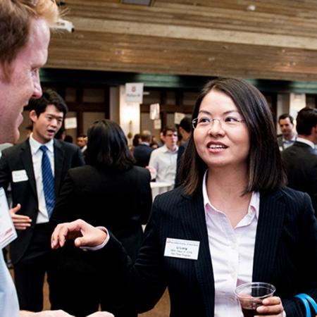 Two MBA students talk together at an event