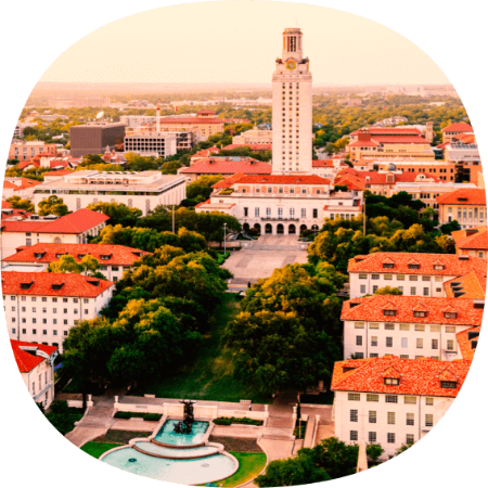 Aerial view of the University of Texas tower and buildings with orange roofs.