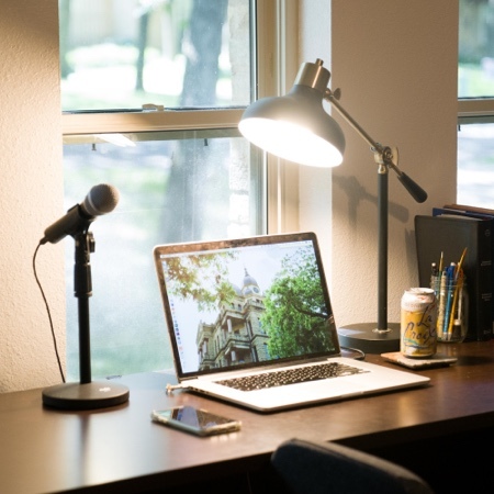 Desk with lamp and microphone on it.