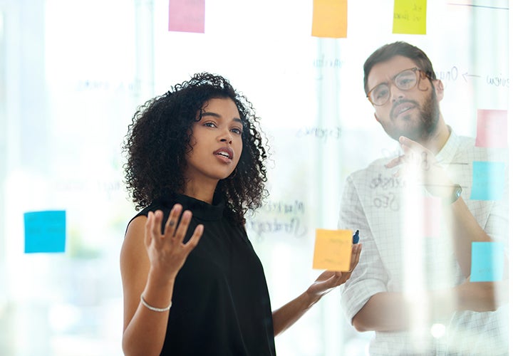 People brainstorming and looking at a board with post-it notes