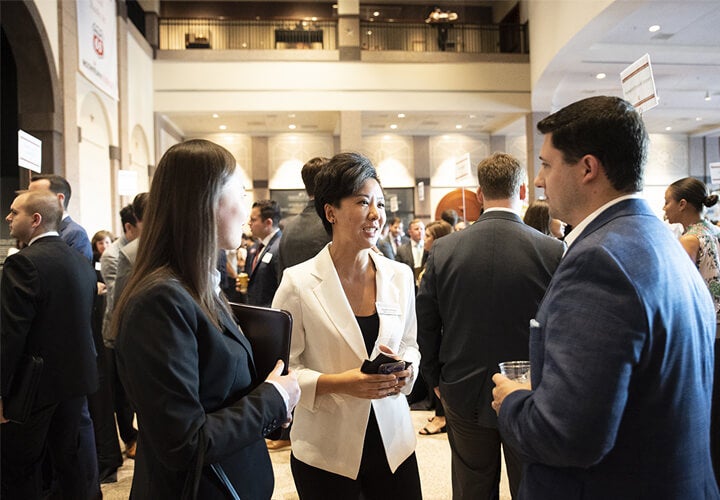 People in business attire talking at an event