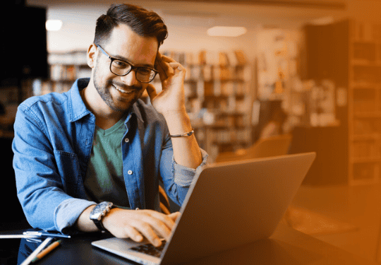 Hildebrand MBA at Texas McCombs student working on laptop computer in library