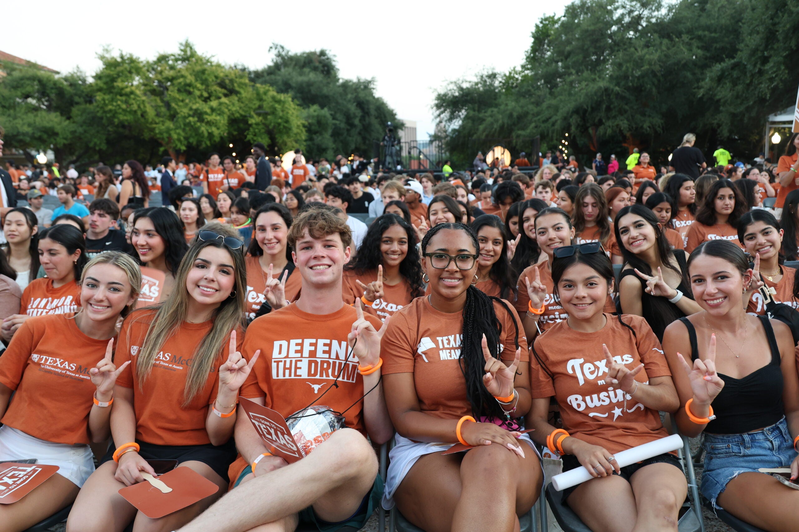 Large crowd of seated students wearing burnt orange.