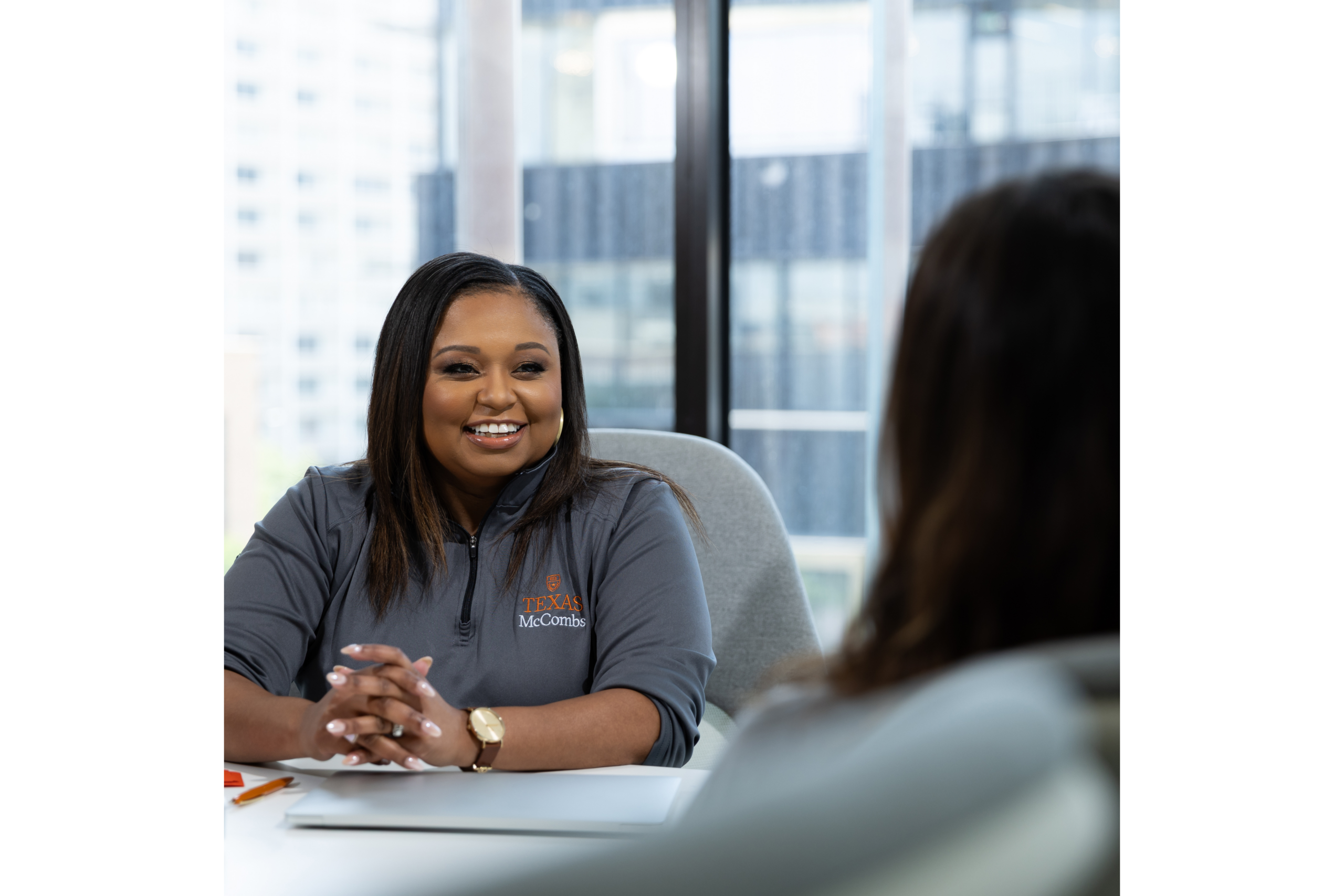 MSTC student talking to someone across form them at a table.