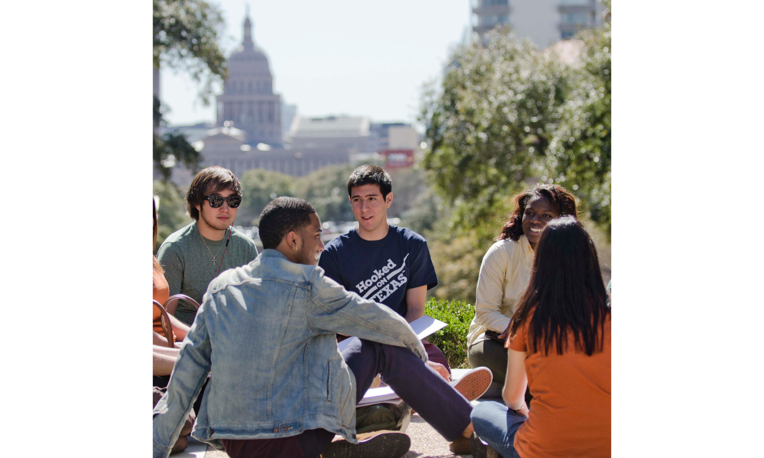 Students sitting and talking with state capital in the background.