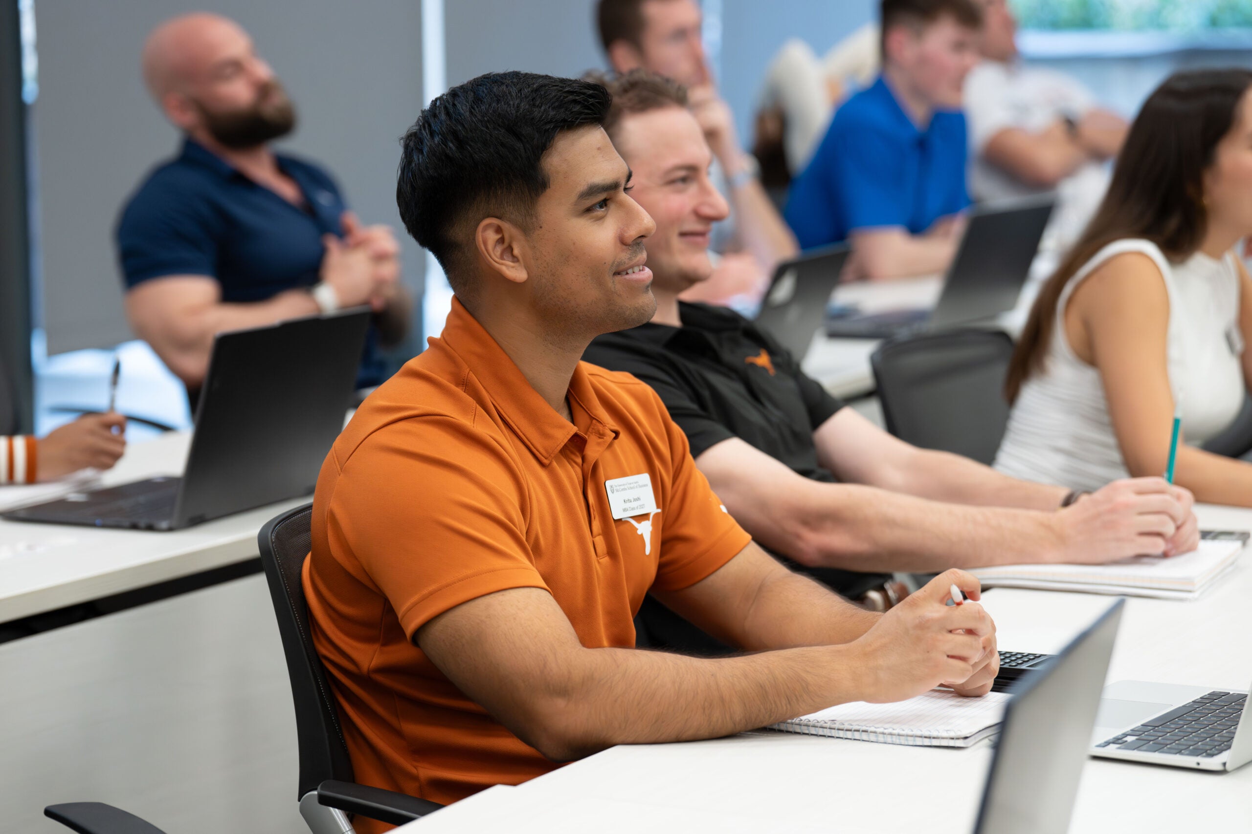 Students sitting in class with laptops