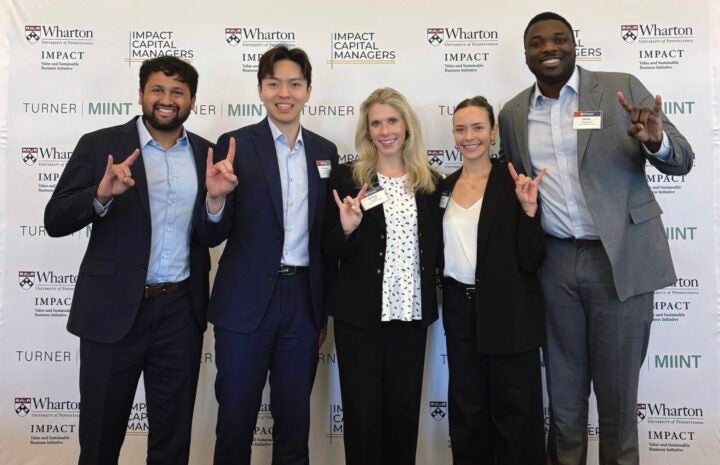 Group of people giving Hook 'Em Horns at MIINT event