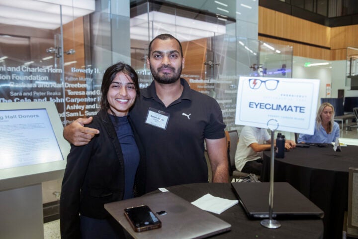 Two people posing at an event booth