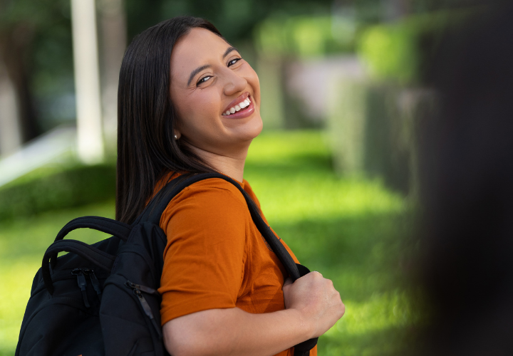 Smiling student stands outside GSB building