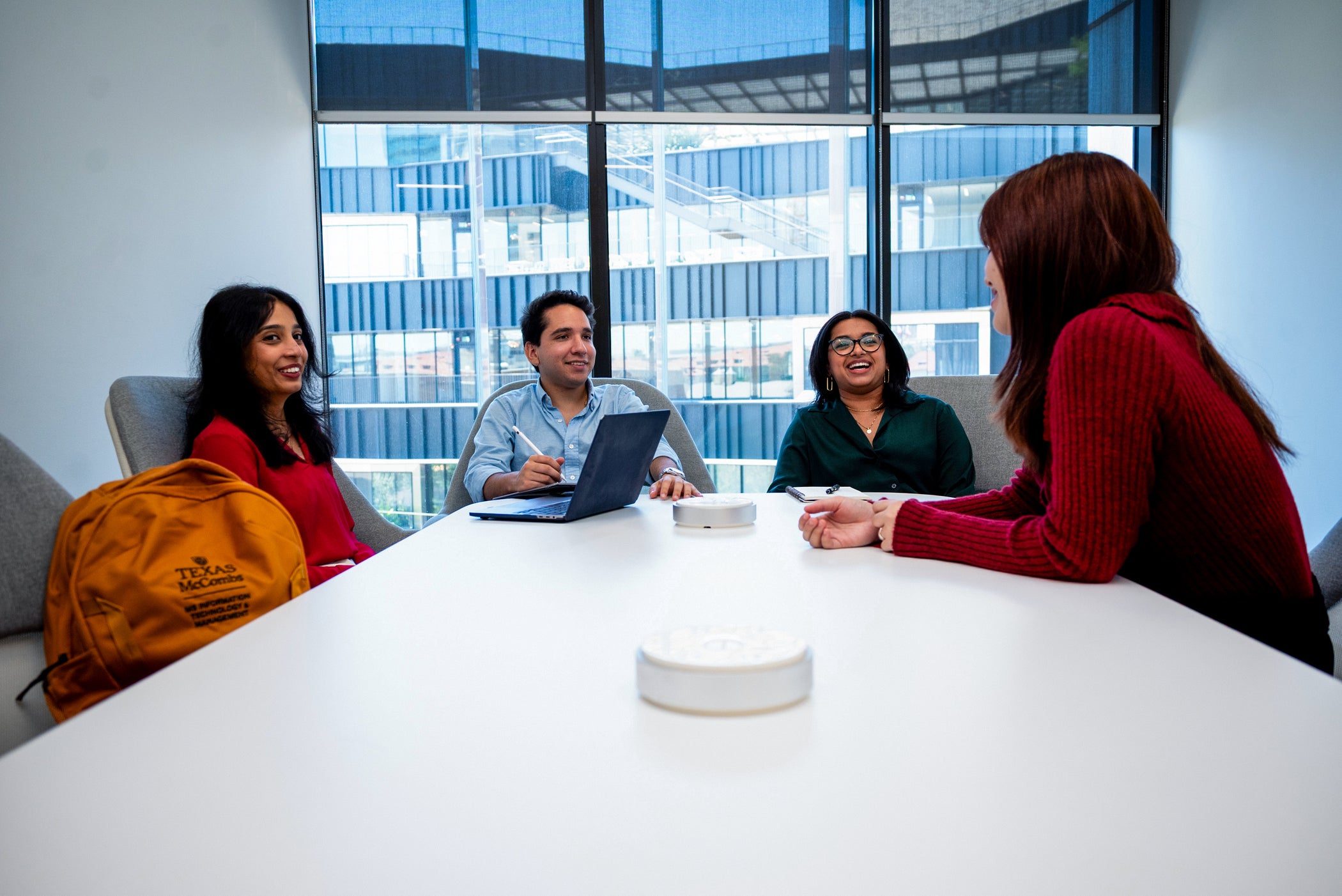 Four MSITM students working in a classroom with The Tower in the background