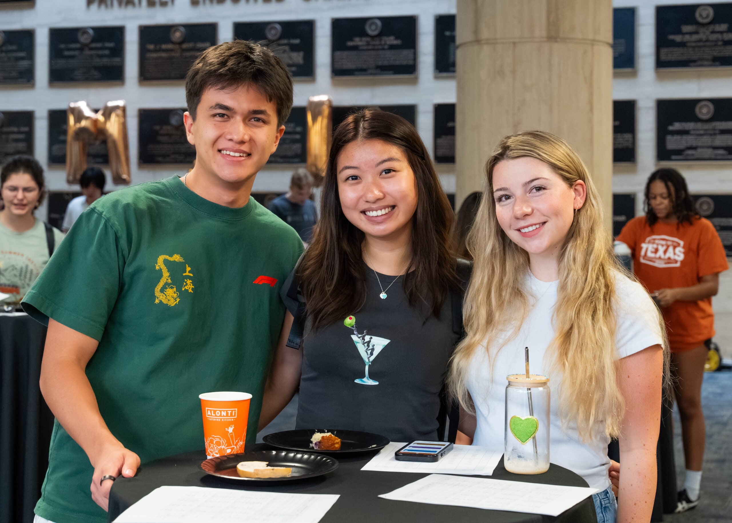 Three students smiling at an event