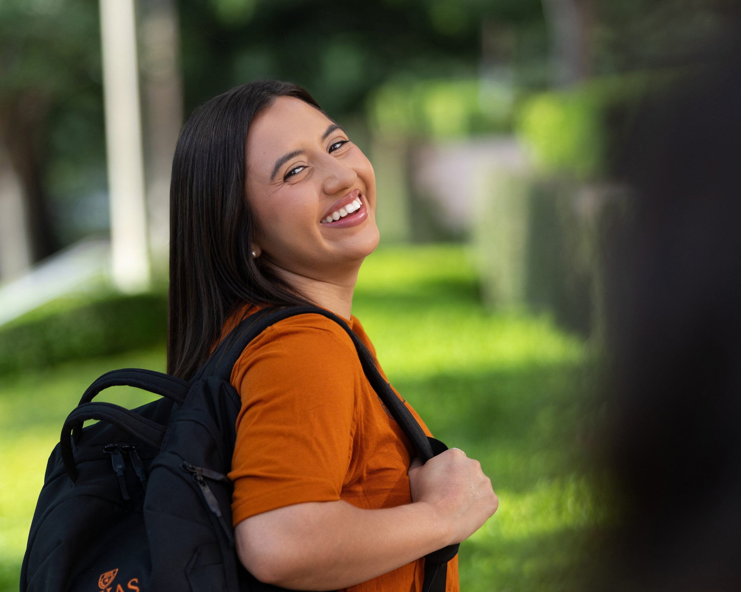 Smiling student stands outside GSB building